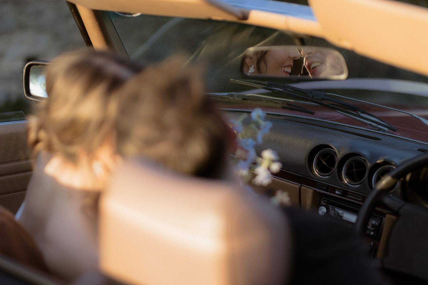Interior view of a car dashboard through the windshield with sunlight streaming in.