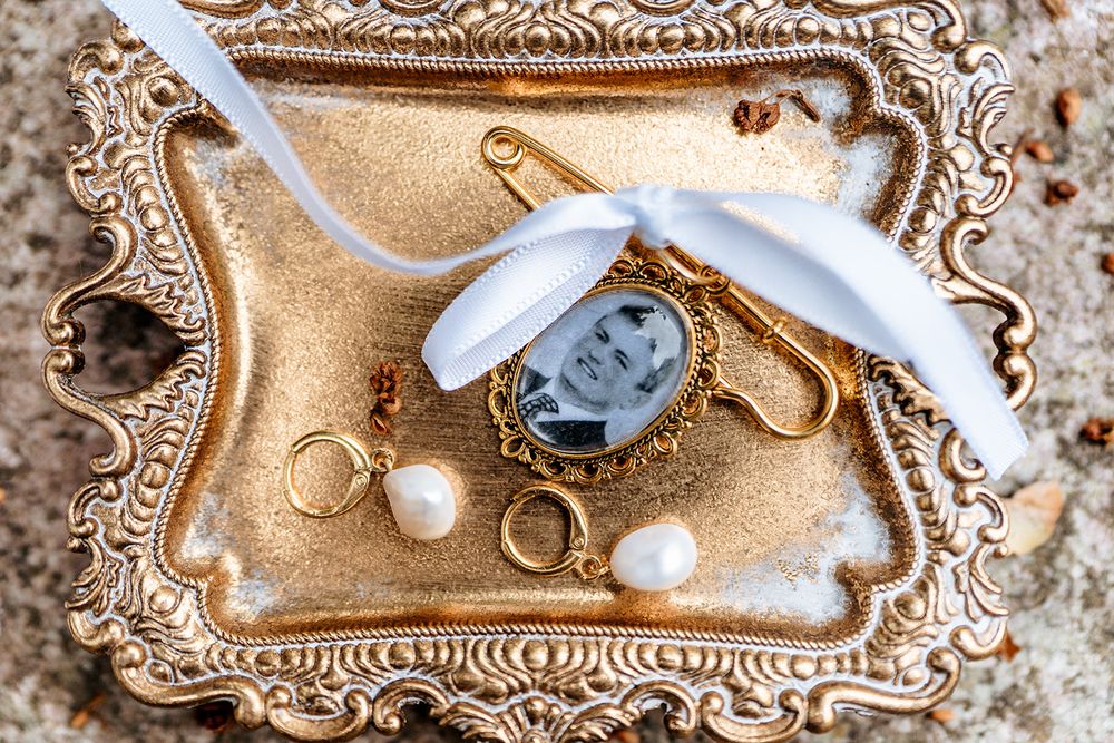 Wedding details featuring rings and jewelry arranged on an ornate gold vintage tray.