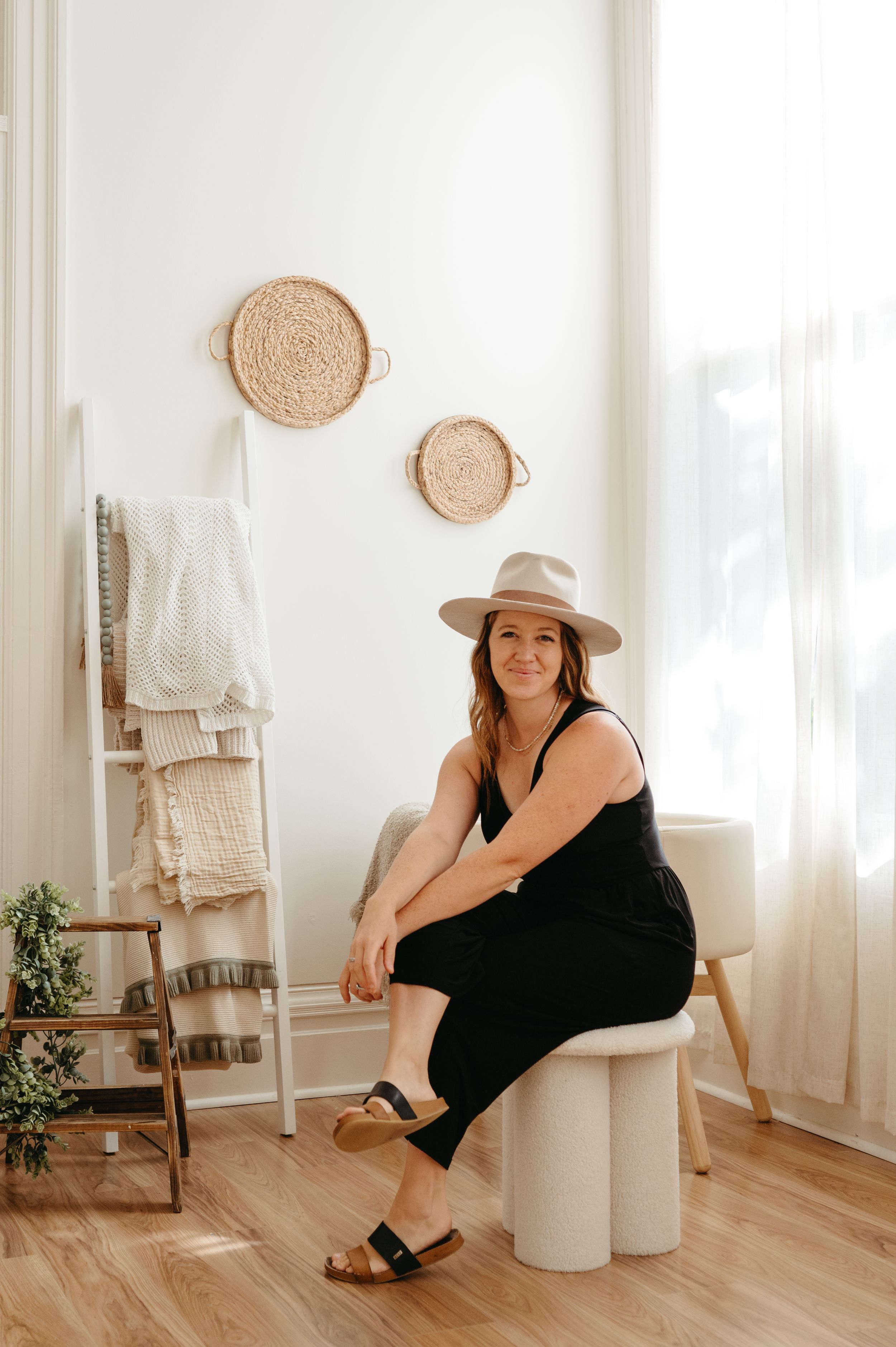 Minimal boho interior with woven wall decor and wooden ladder shelf.