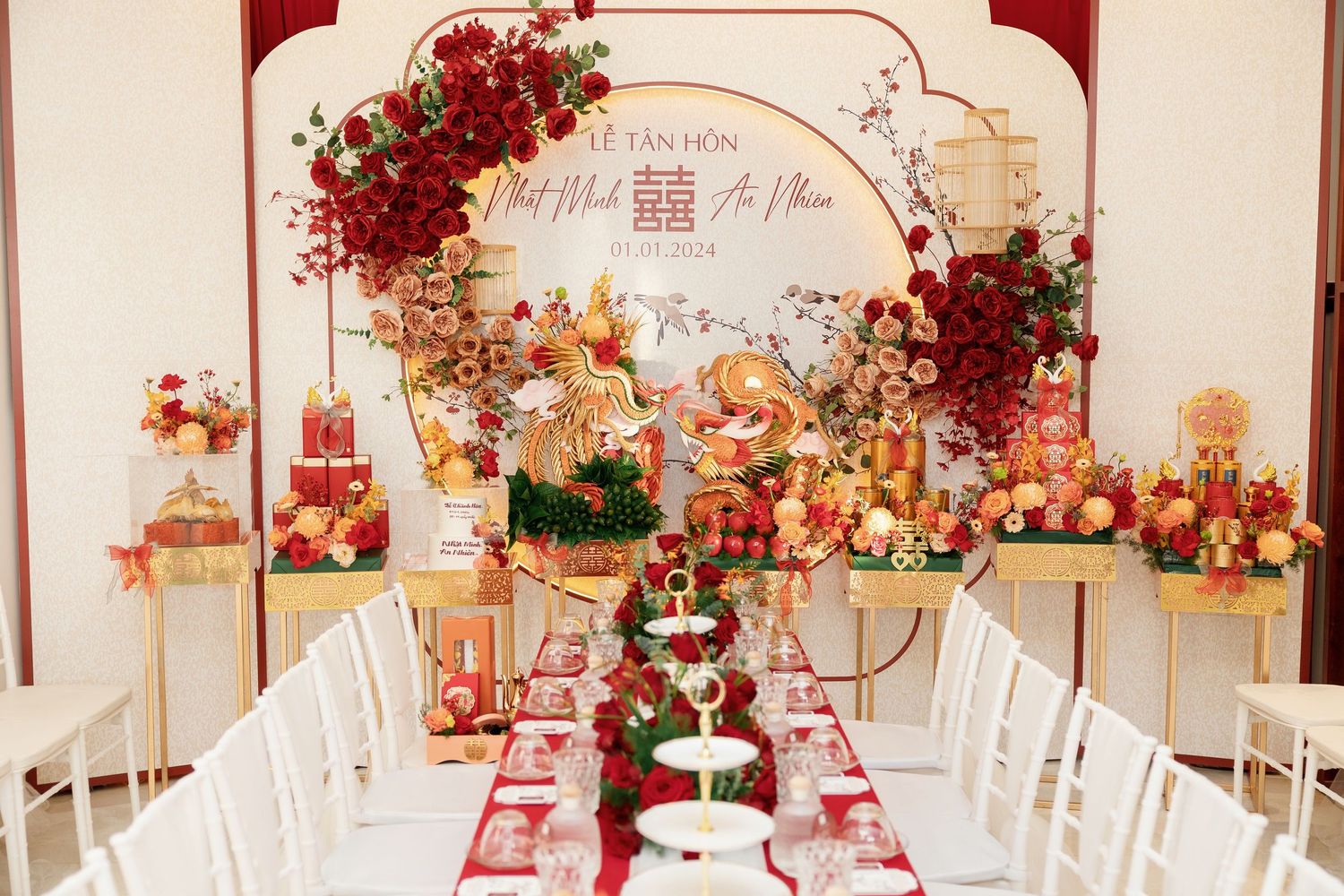 Elegant wedding reception table decorated with red and white flowers and golden accents.