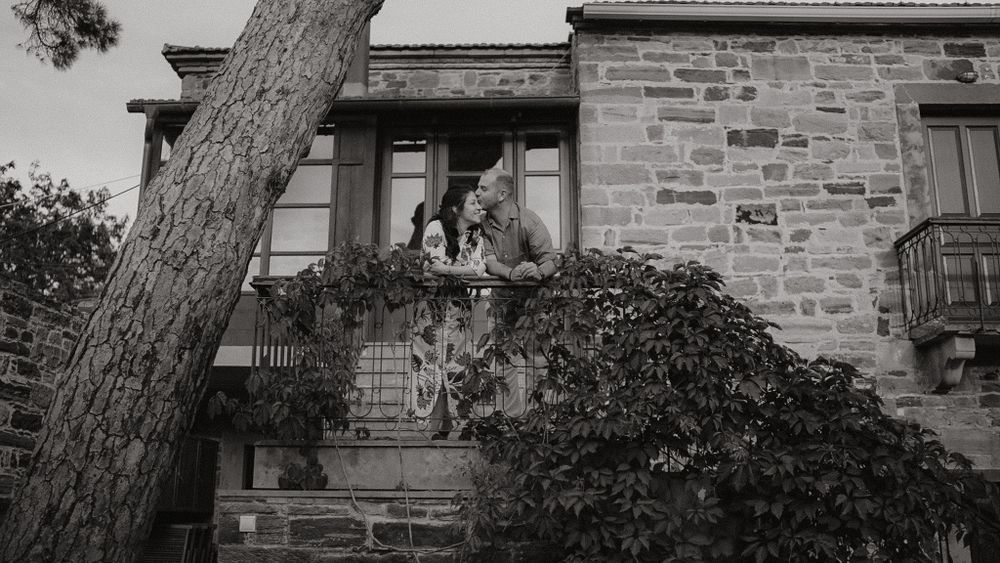 A rustic stone house exterior with climbing vines and architectural details in black and white.