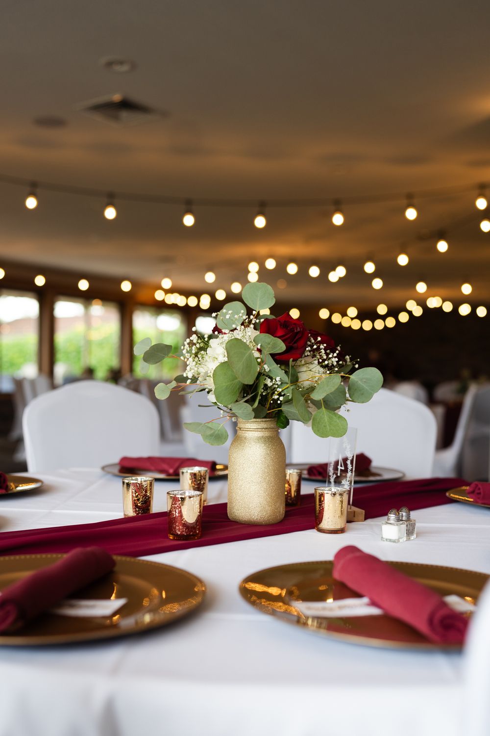 wedding table decor, roses in gold vase with gold candle holders and a number 4 table number