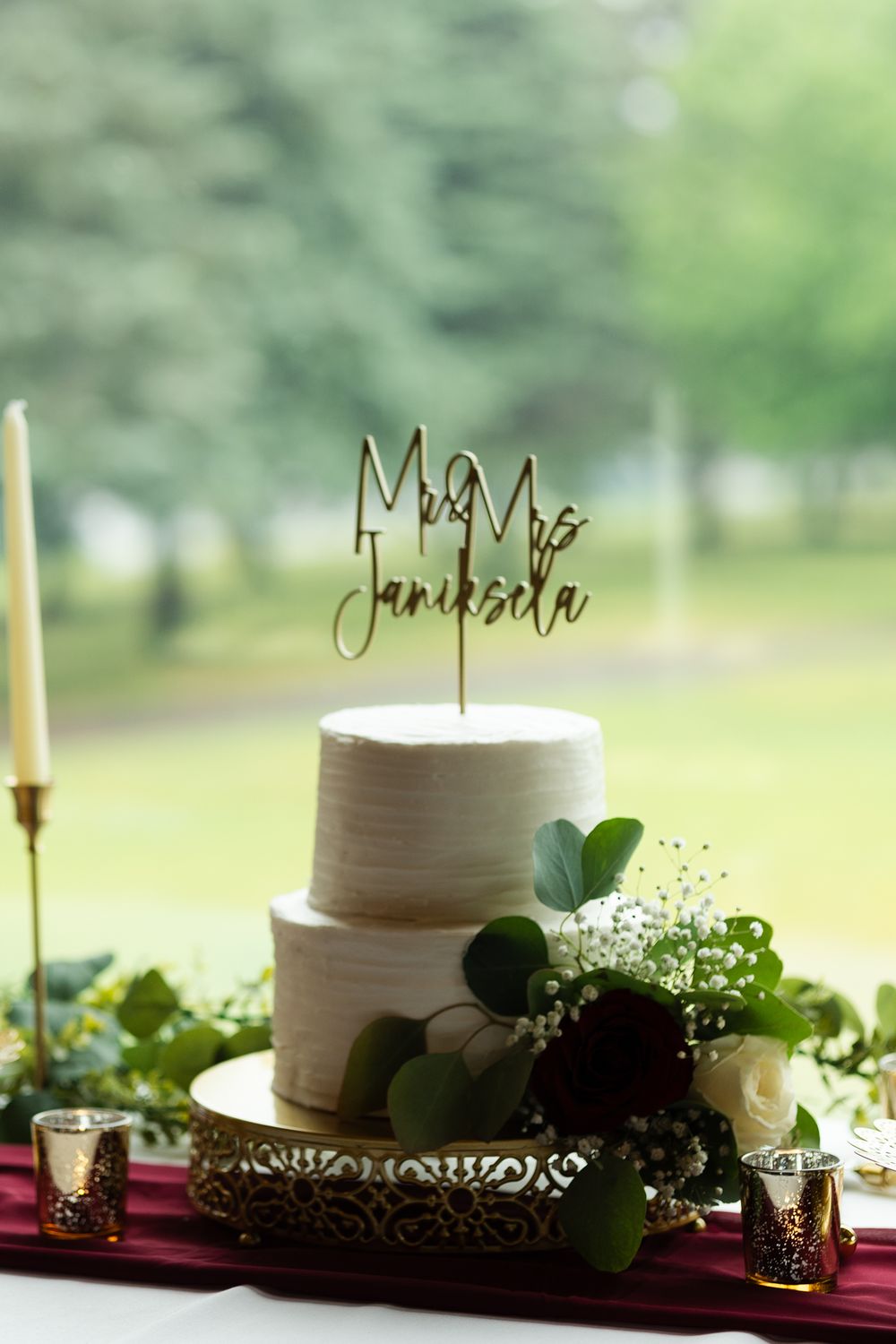 wedding cake close up with the couple's name cake topper in focus at the Pebble Creek Golf Course in Becker, MN