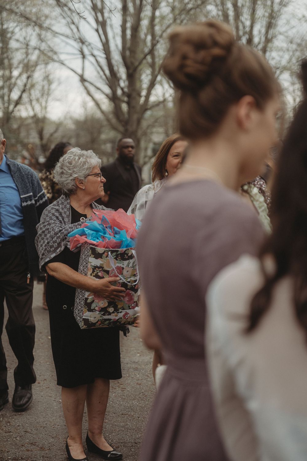 Wedding guests mingle and exchange gifts at an outdoor reception.