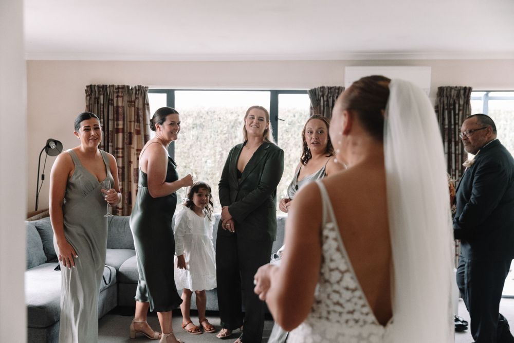 Wedding party members gather in a room as they prepare for the special occasion.