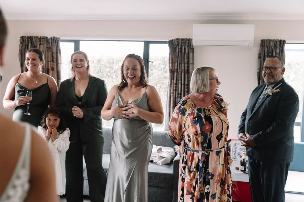 A group of wedding guests react with joy and emotion during a special moment.