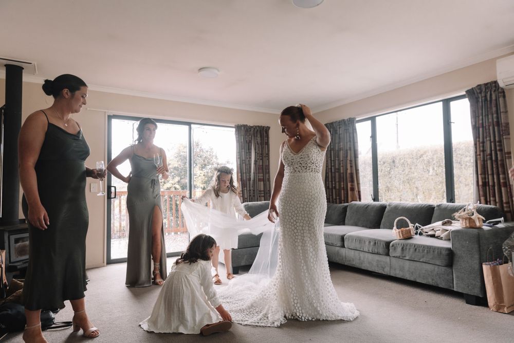 A beautiful wedding dress is showcased while guests gather in a modern living room setting.