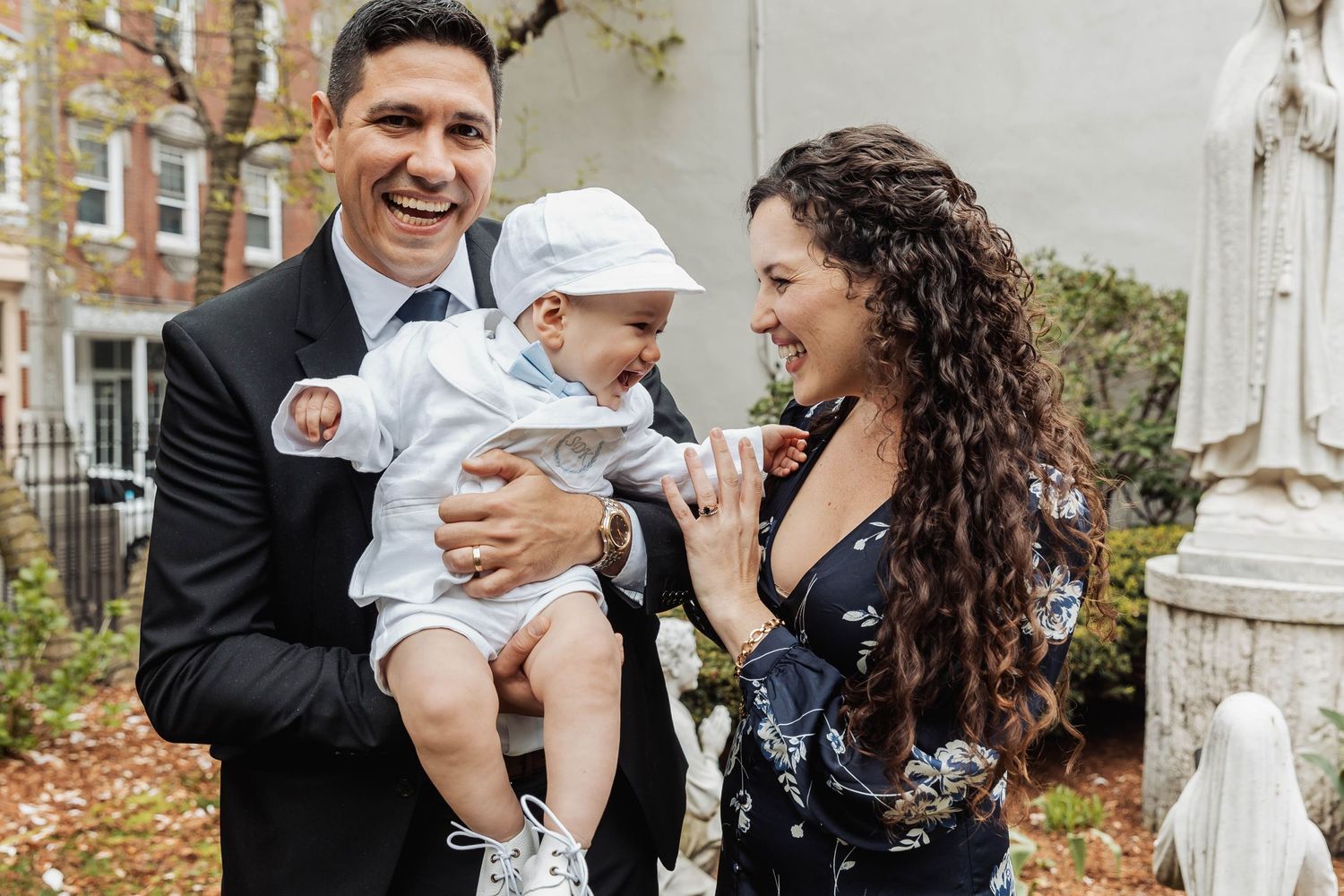 Family sharing joyful moments outdoors after a baptism ceremony.