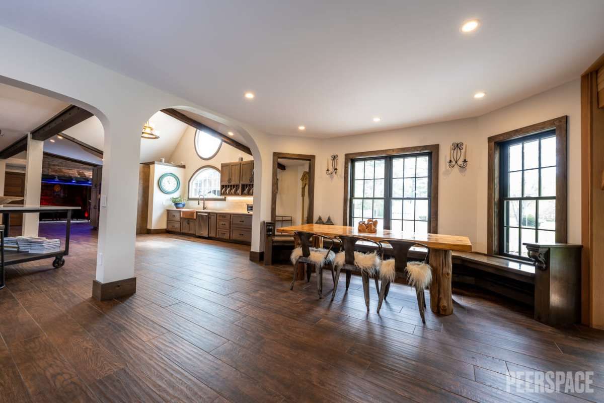 Spacious open-concept living area with hardwood floors, multiple windows, and elegant dining space.