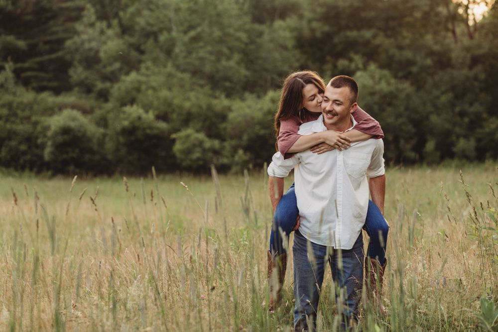 Professional photo of a man giving a woman a piggy back ride outdoors