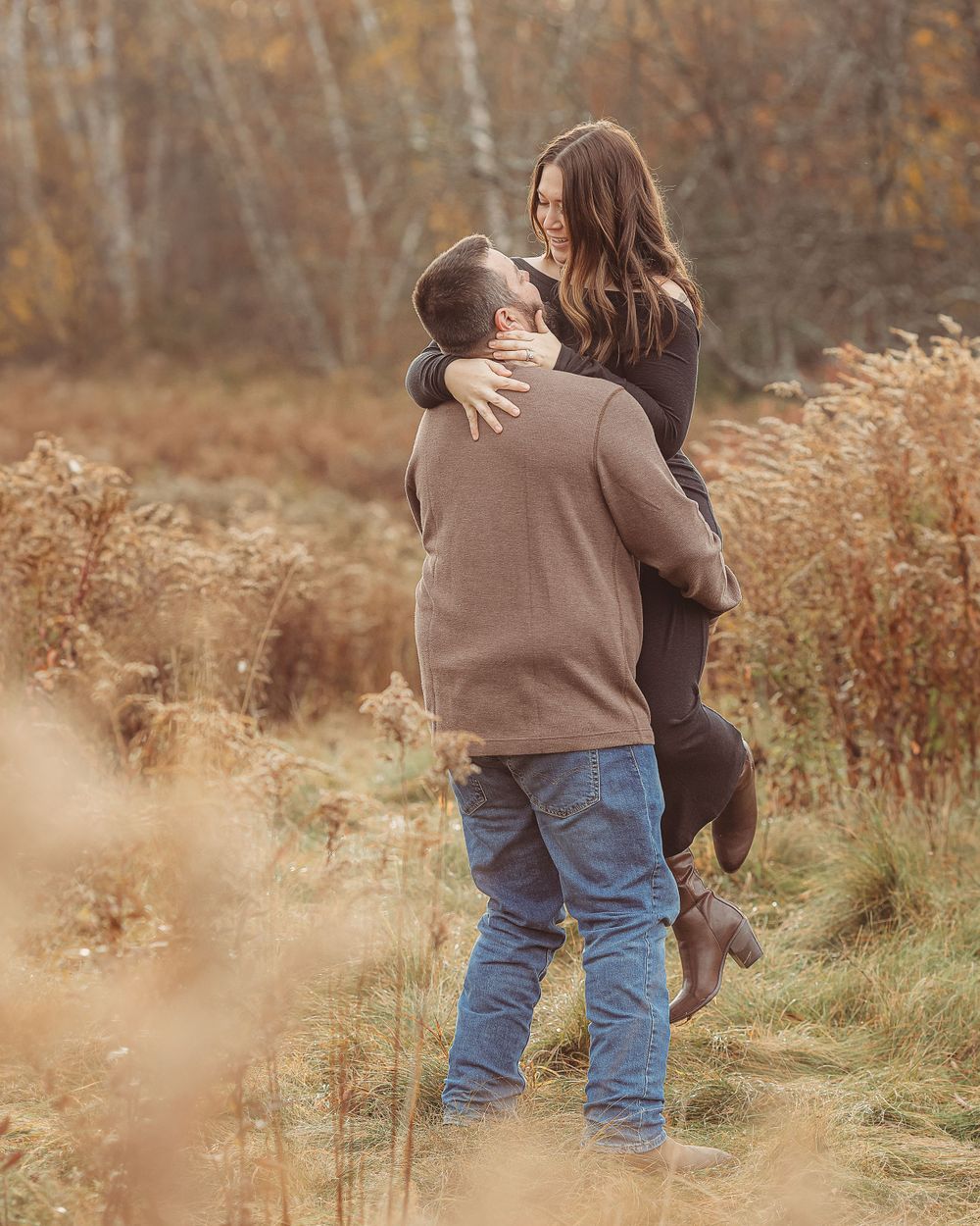 Professional photo of man lifting woman up outdoors