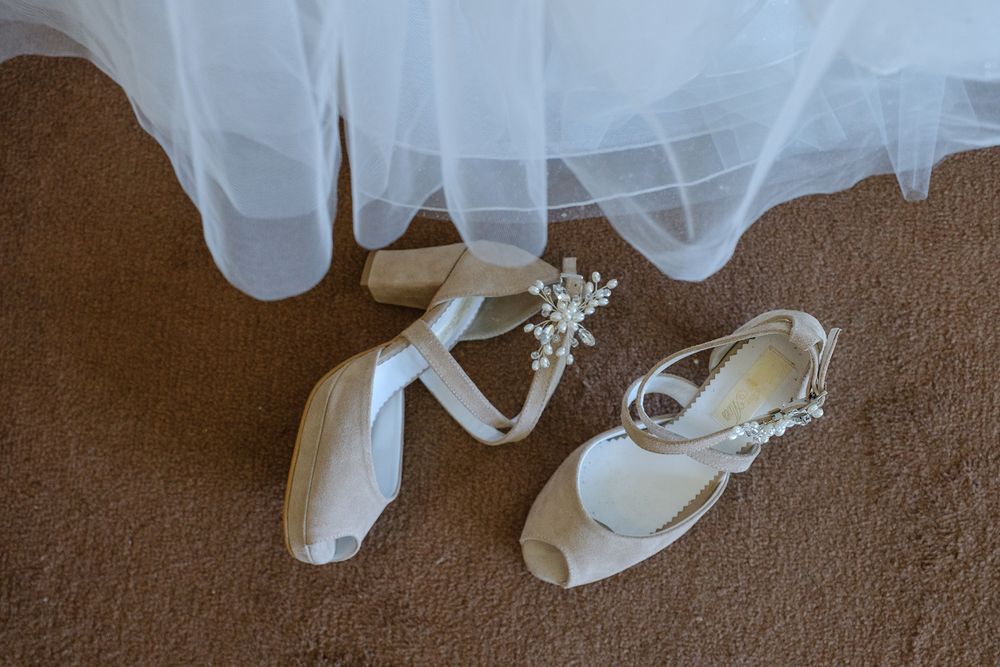 White wedding veil gently flowing against a dark brown background.