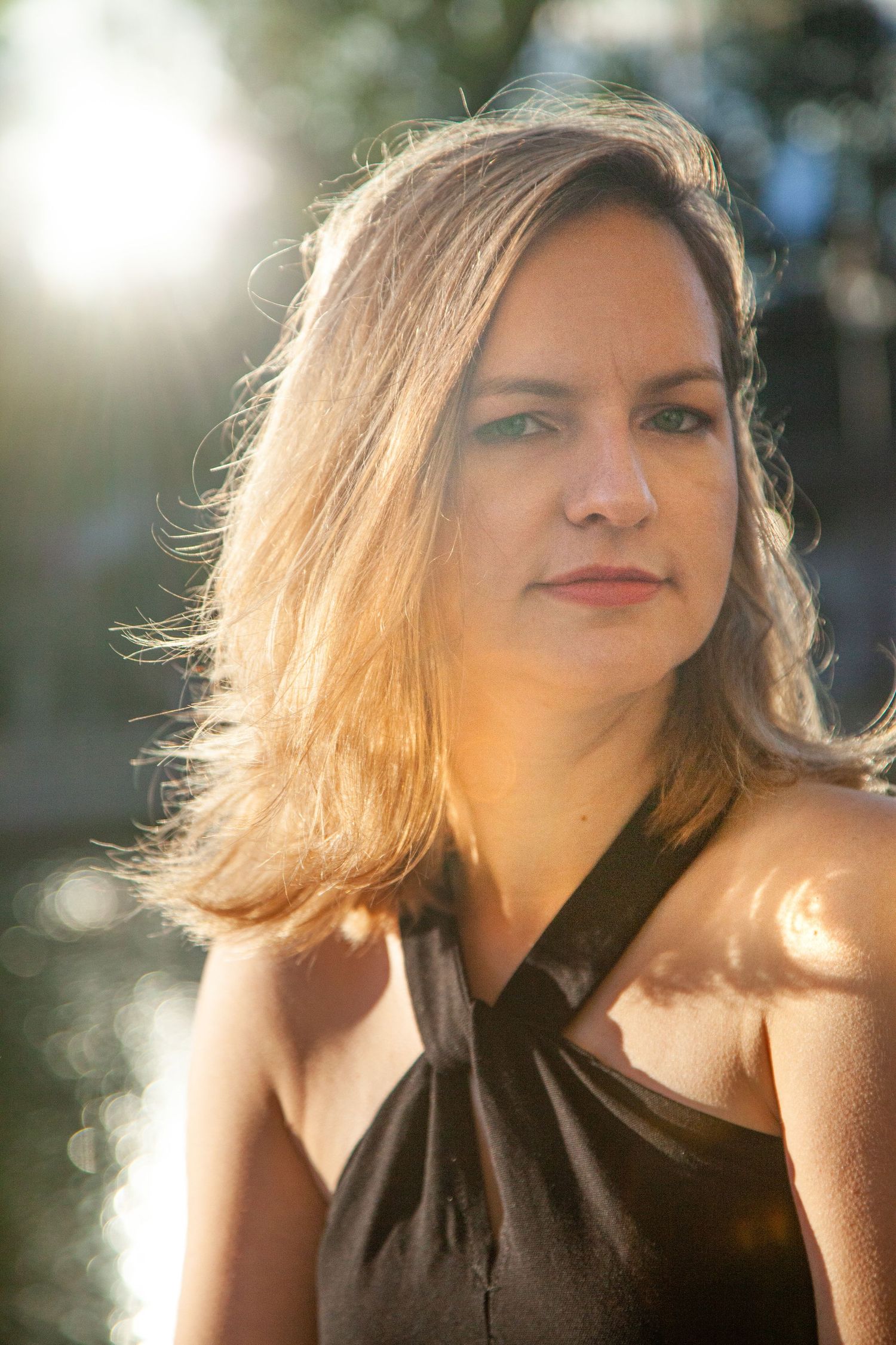 Warm sunlit portrait with golden backlighting and natural bokeh effect.