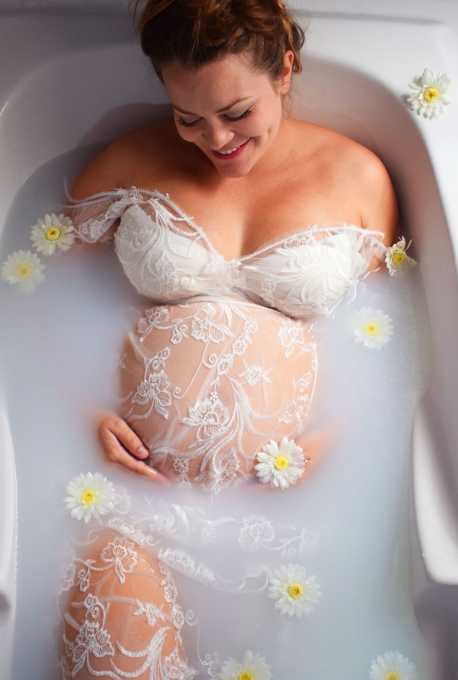 Photographie d'une femme enceinte dans son bain de lait