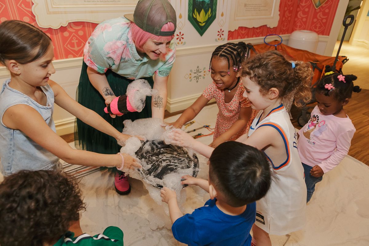 Excited children immersed in a mesmerizing bubble show at a Moana-themed birthday party in NYC