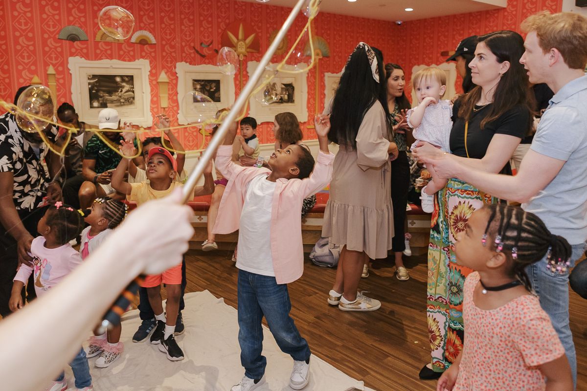 Birthday boy watches in awe as bubbles fill the air, celebrating his Moana-themed party with magical entertainment.