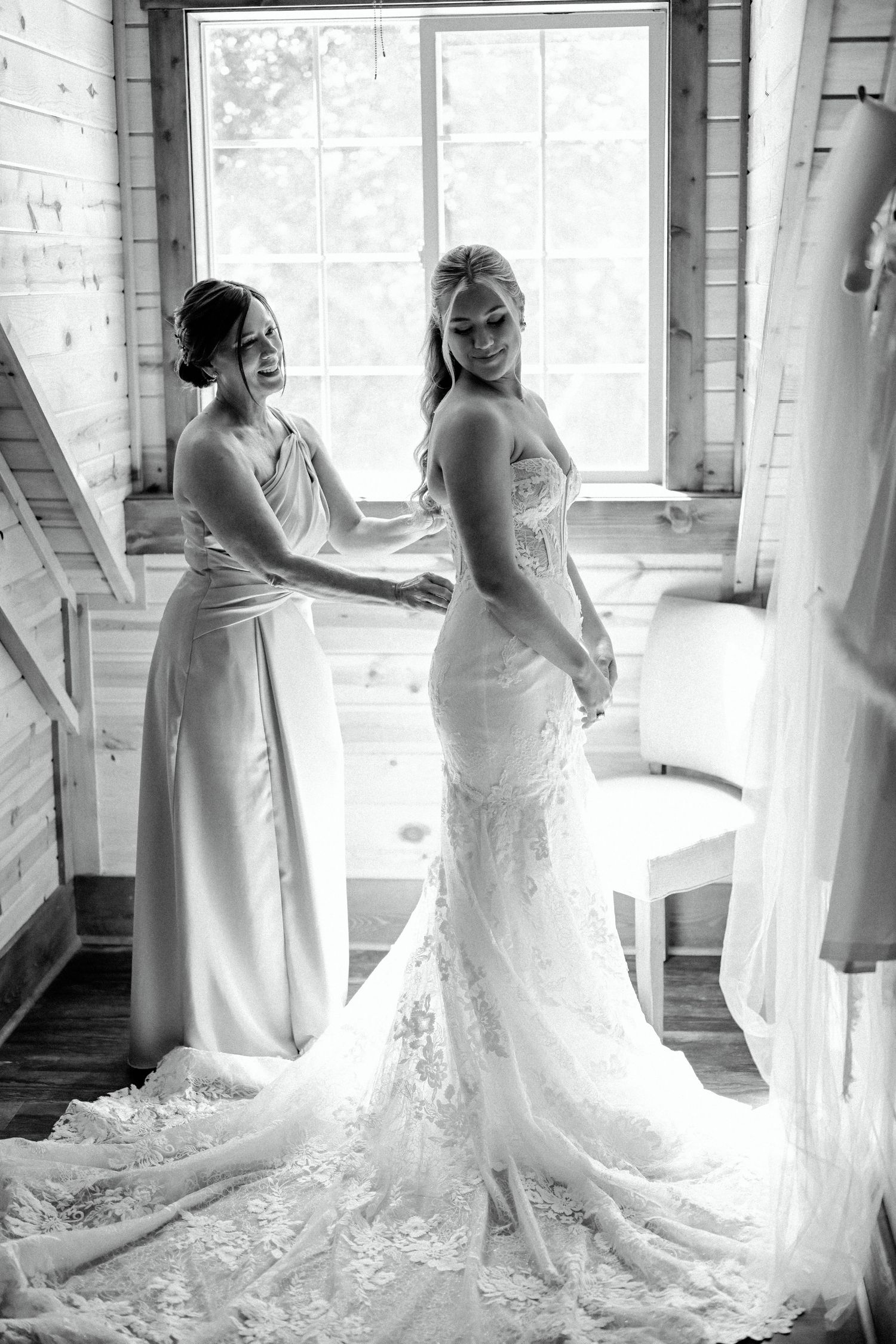 A series of black and white bridal portraits showing a wedding gown with a flowing train in a rustic interior setting.