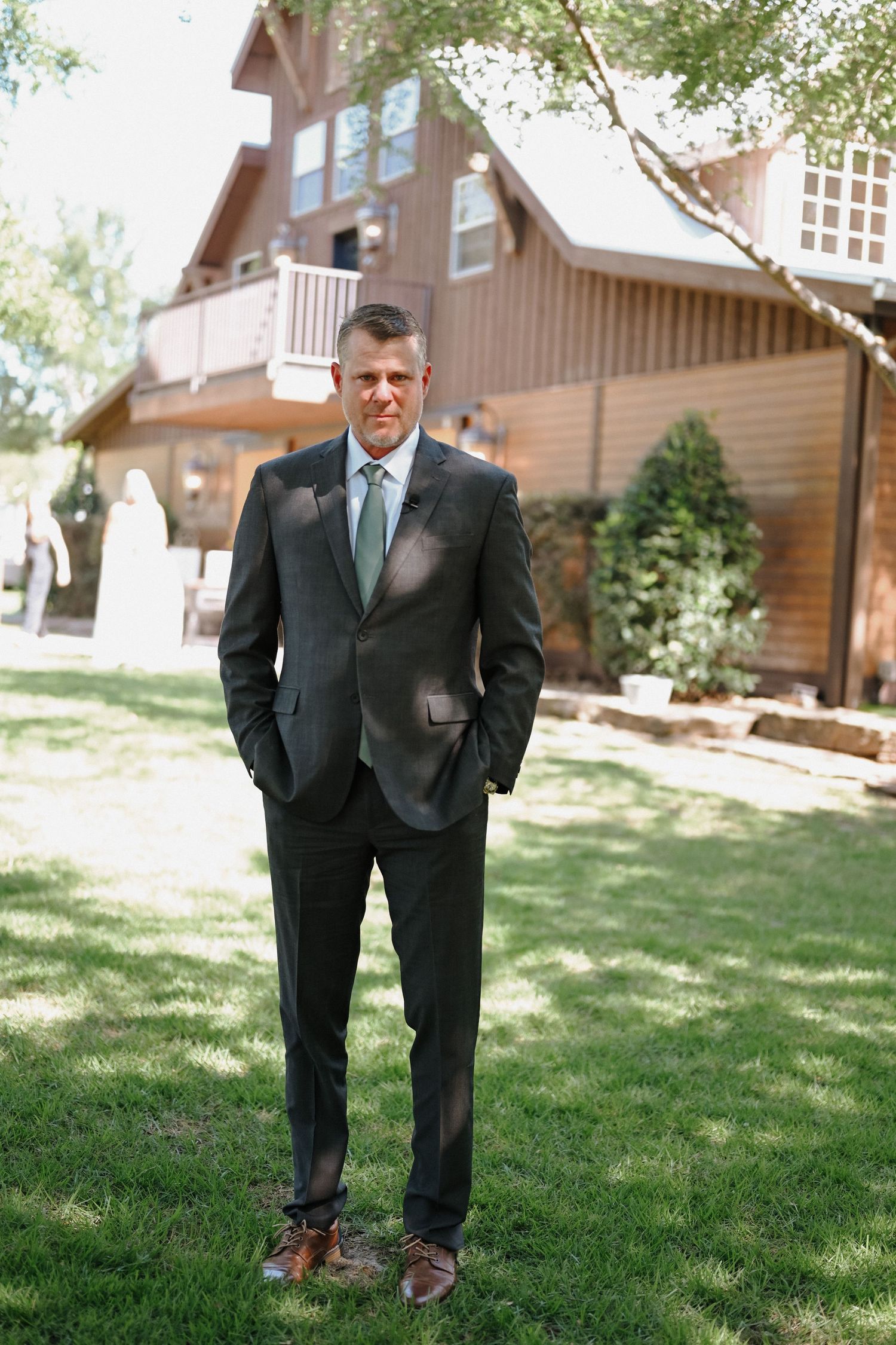 A series of outdoor portraits showing a groom in a dark suit and green tie standing on grass.