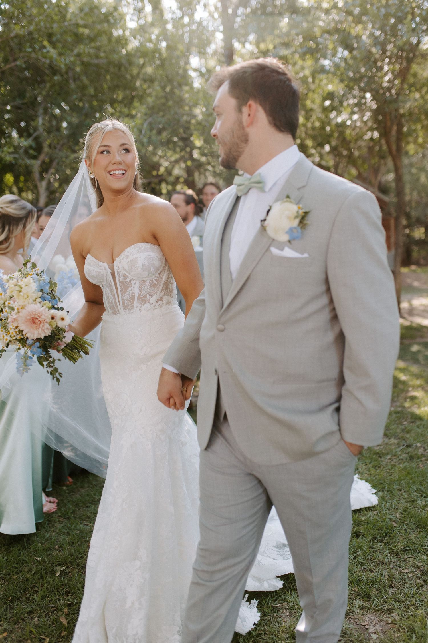 A couple shares a joyful moment during their outdoor garden wedding ceremony.