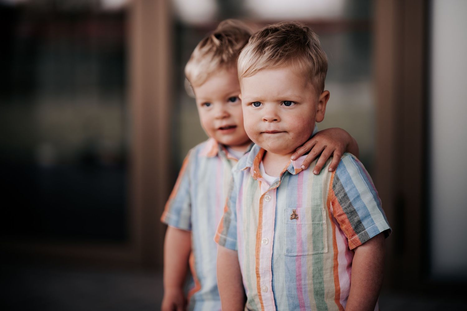 Twee jonge kinderen met gestreepte overhemden aan staan samen.