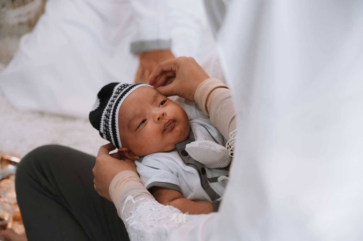 Holding baby during Akikah