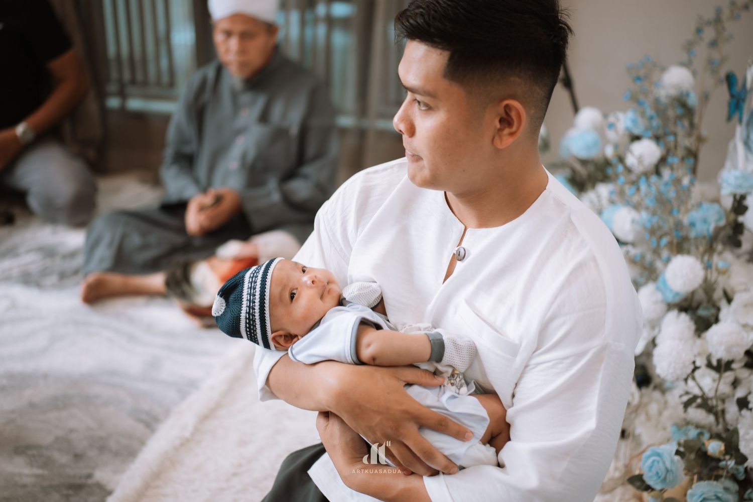 Holding baby during Akikah