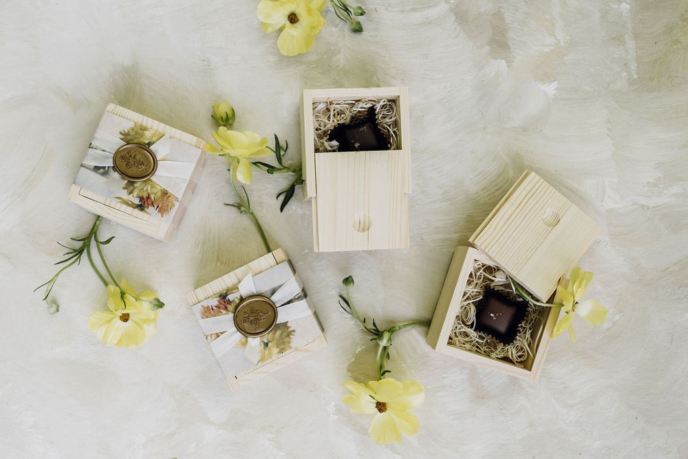 Vintage photographs arranged with delicate yellow flowers on white fabric.