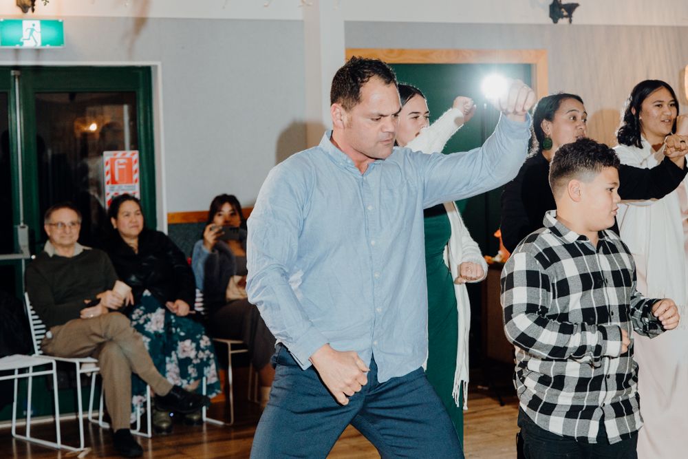 People dancing energetically during a celebration in a well-lit indoor venue.