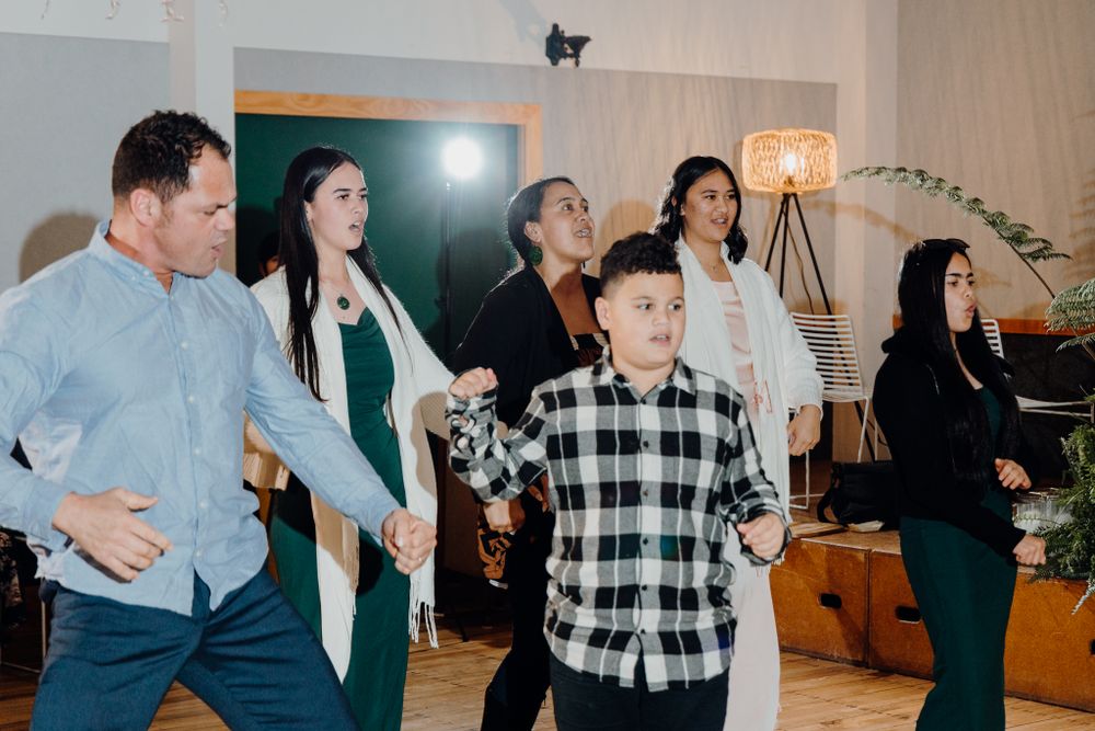 Group dancing together in a line formation at an indoor event space.