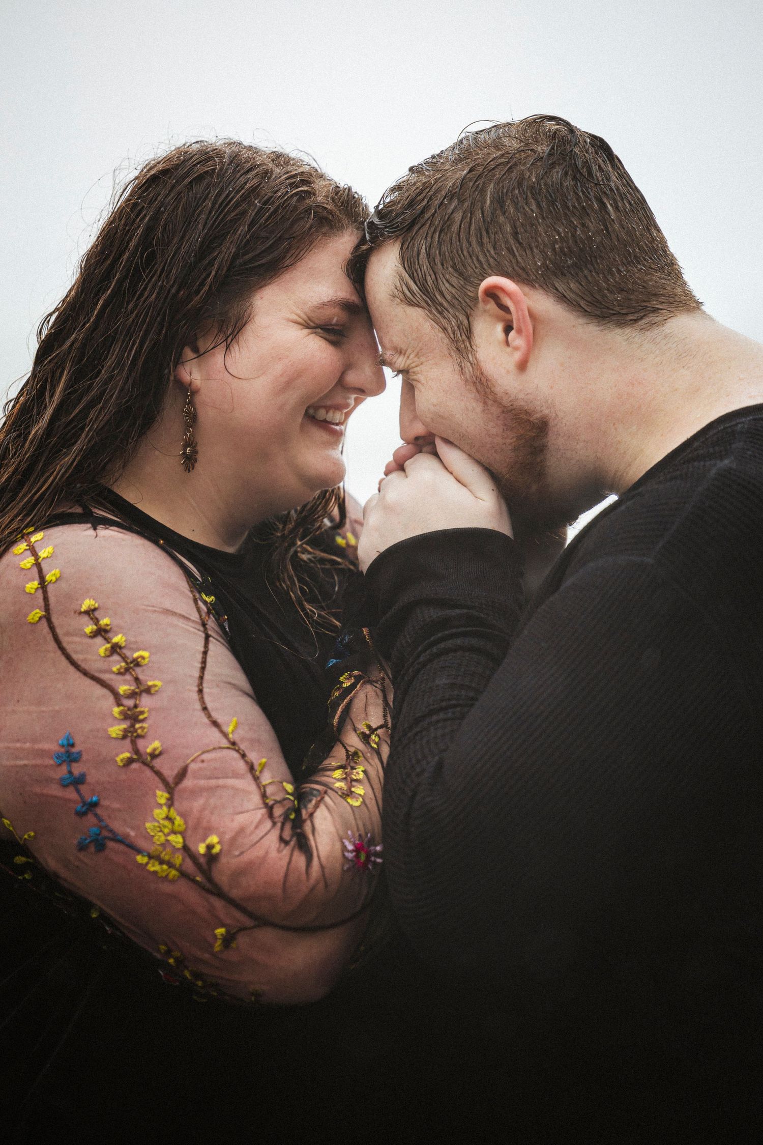 Intimate close-up of a romantic couple sharing a tender moment while wearing pink and black clothing.