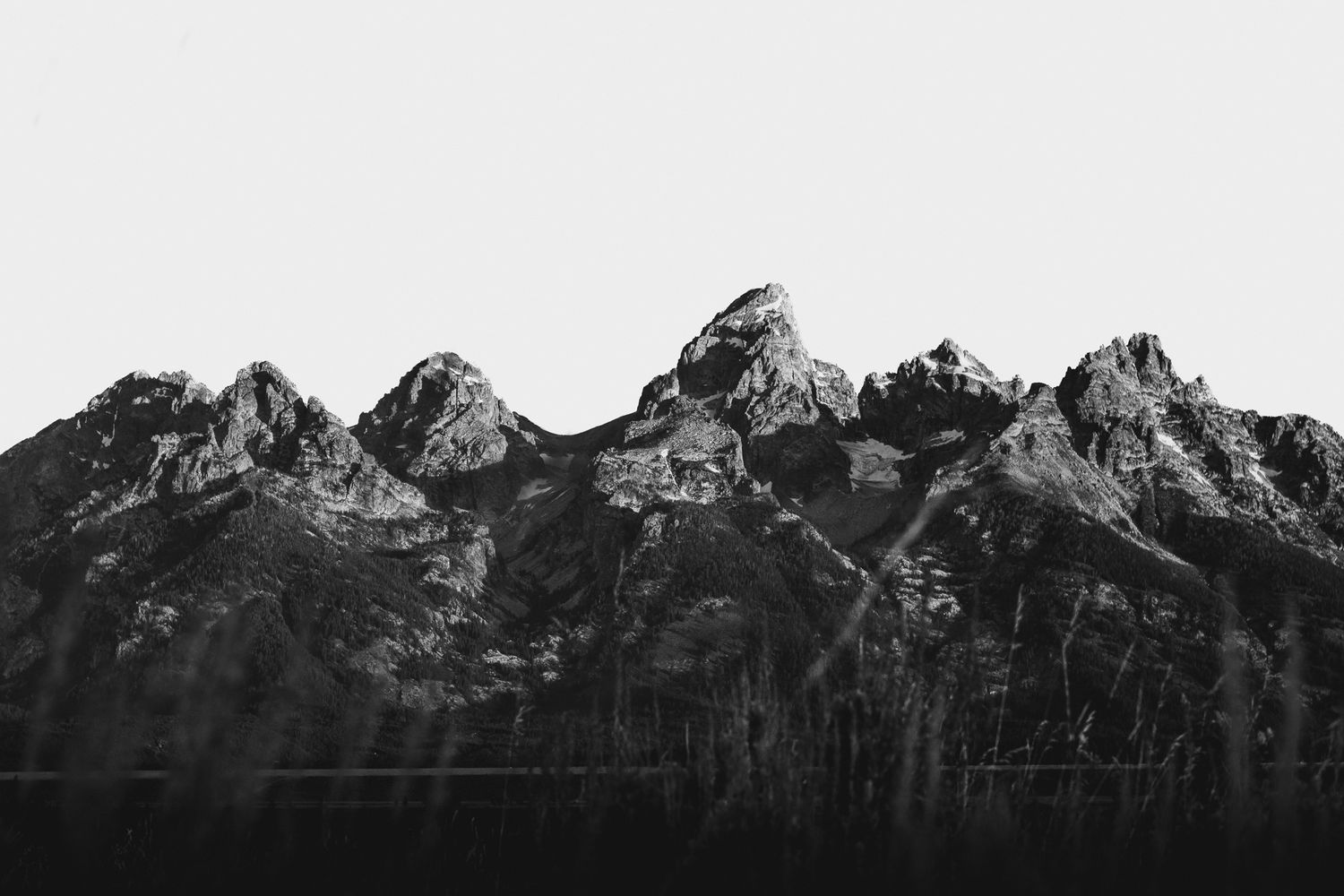 Panoramic view of the Tetons in grand Teton national park, their jagged mountain peaks in black and white.