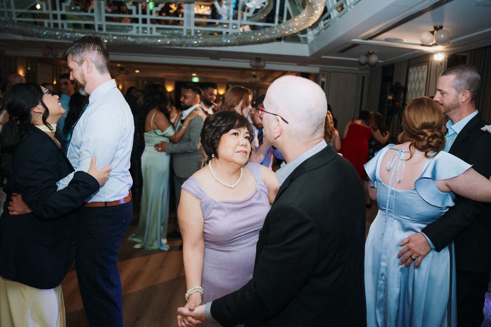 Couples dancing together during a wedding reception in an elegant ballroom.