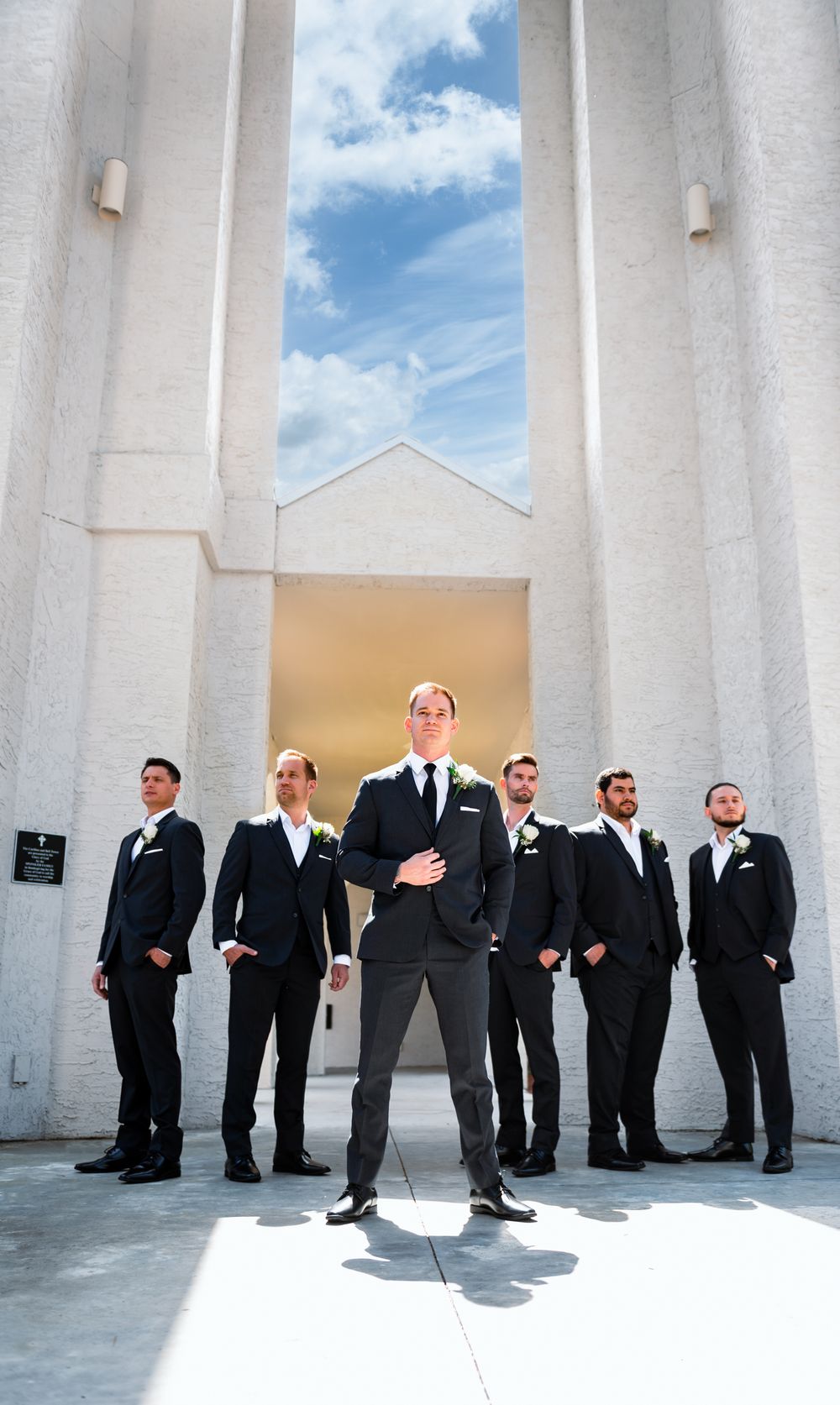 Group portrait of groom and groomsmen in sharp tuxedos with brick backdrop at Canterbury Hall