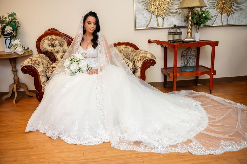 Bride sitting gracefully in her wedding dress, hands resting on her lap, ready for ceremony