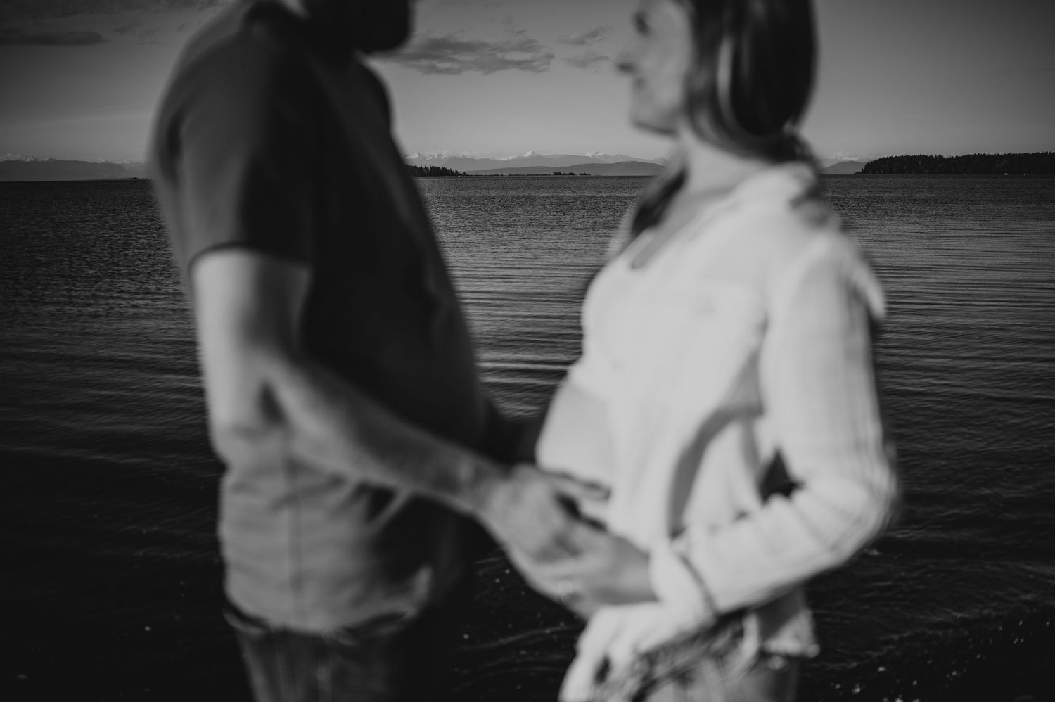 Black and white photo pregnant couple belly in front of ocean in Union Bay on Vancouver island Maternity and Outdoor photographer