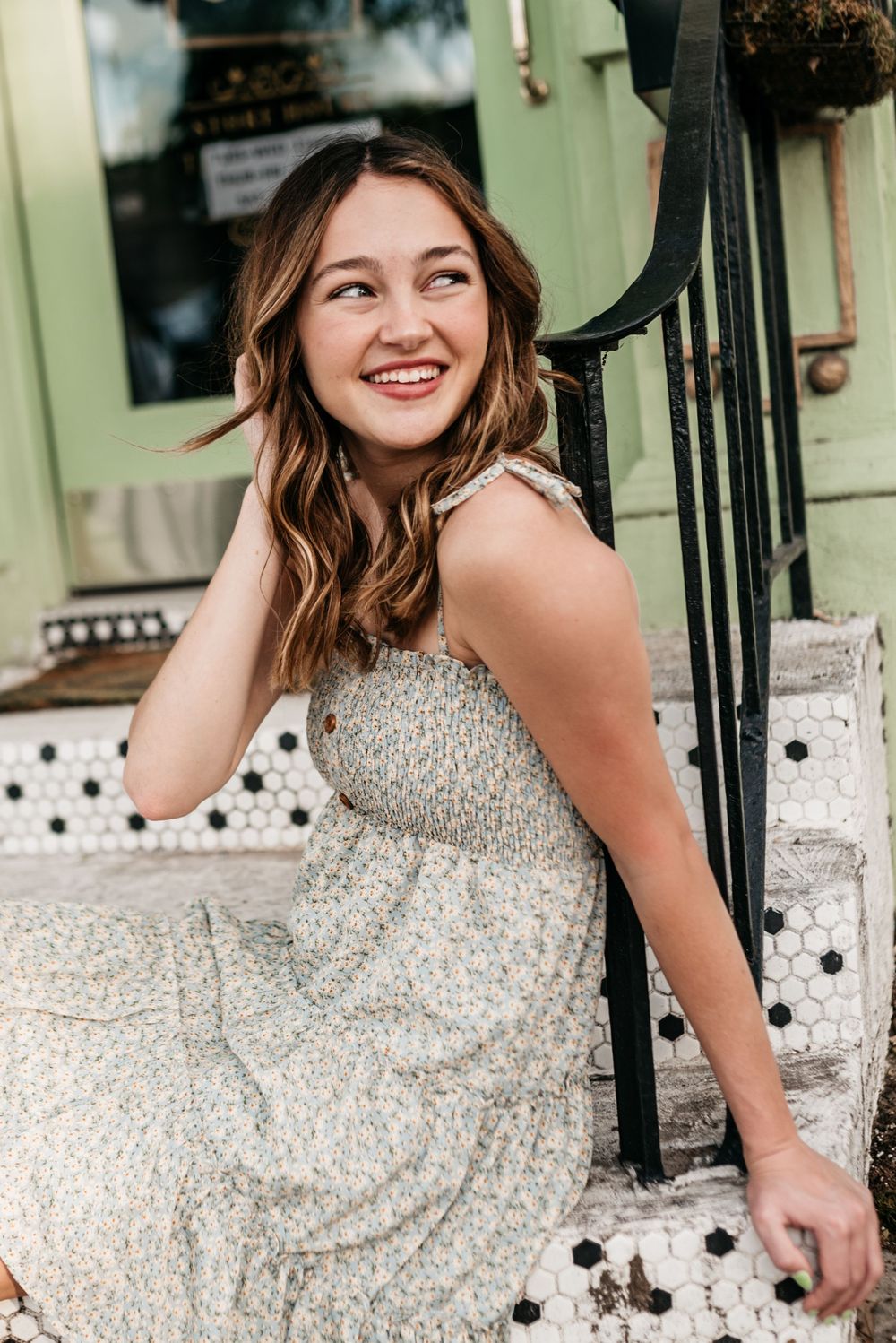 A joyful moment captured on outdoor steps with a sparkly beige dress and wrought iron railing.