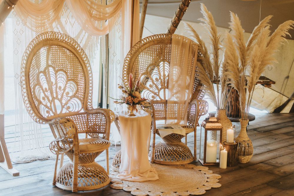 Peacock chair set up with floral arrangements and greenery creates an elegant boho wedding setup at Nuddock Wood Lake.