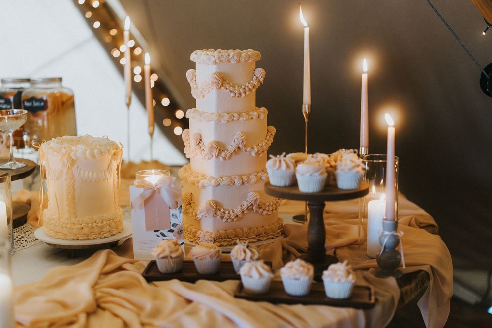 Elegant white wedding cakes with gold accents and delicate floral details at Nuddock Wood Lake.