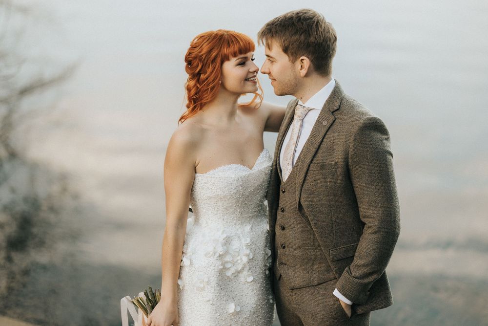 A romantic couple in wedding attire poses together at Nuddock Wood Lake - taken by Grimsby photographers.