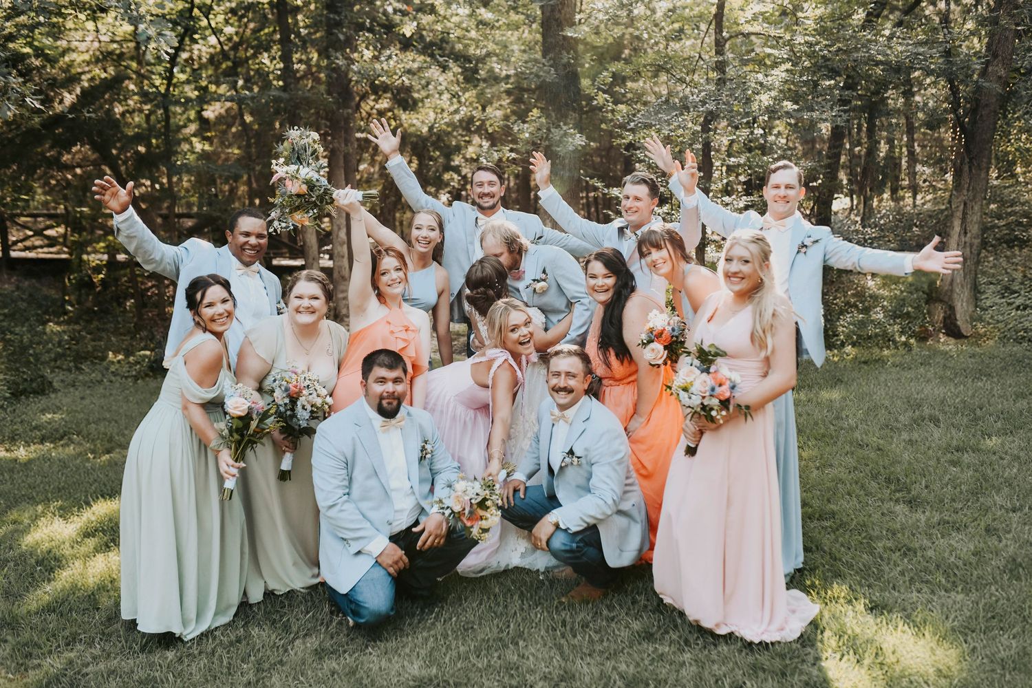 Full wedding party jumping mid-air with big smiles and wild energy
