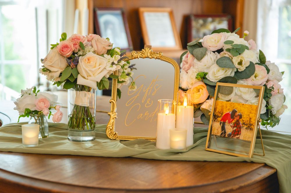 Elegant wedding reception table decor featuring peach roses and white candles in a softly lit room.