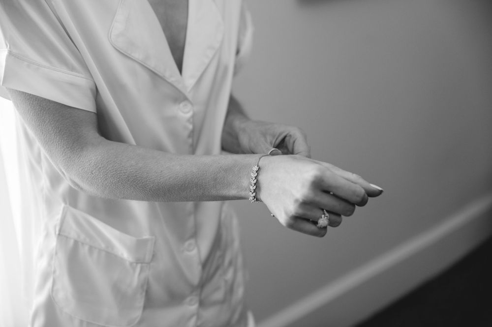 Medical professional in white coat checking their wrist watch in a clinical setting.