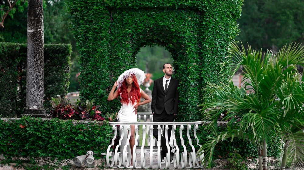 Couple framed by palm trees near Vizcaya’s courtyard, taken by wedding photographers in Florida.