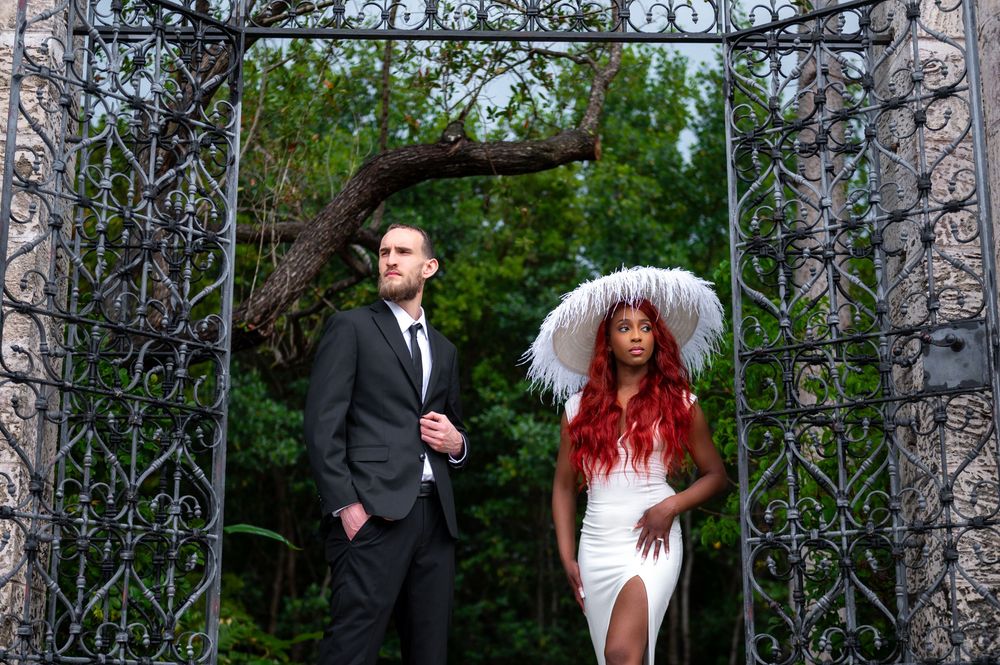 Couple sharing a quiet moment beneath tropical foliage at Vizcaya, captured by Palm Beach wedding photographers.