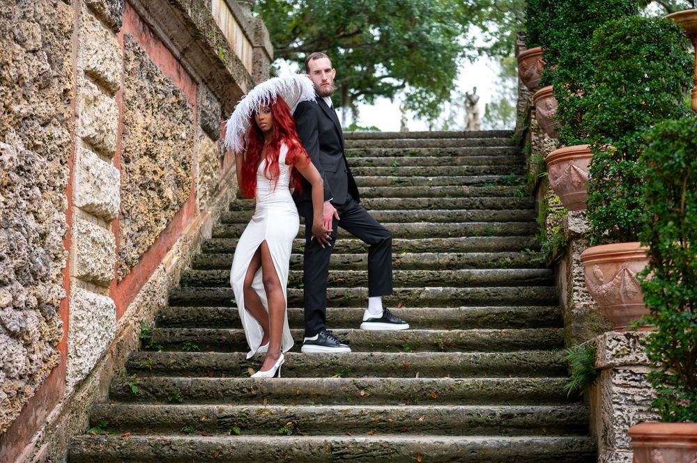 Couple embracing in front of Vizcaya’s grand staircase, captured by luxury wedding photographers in Florida.