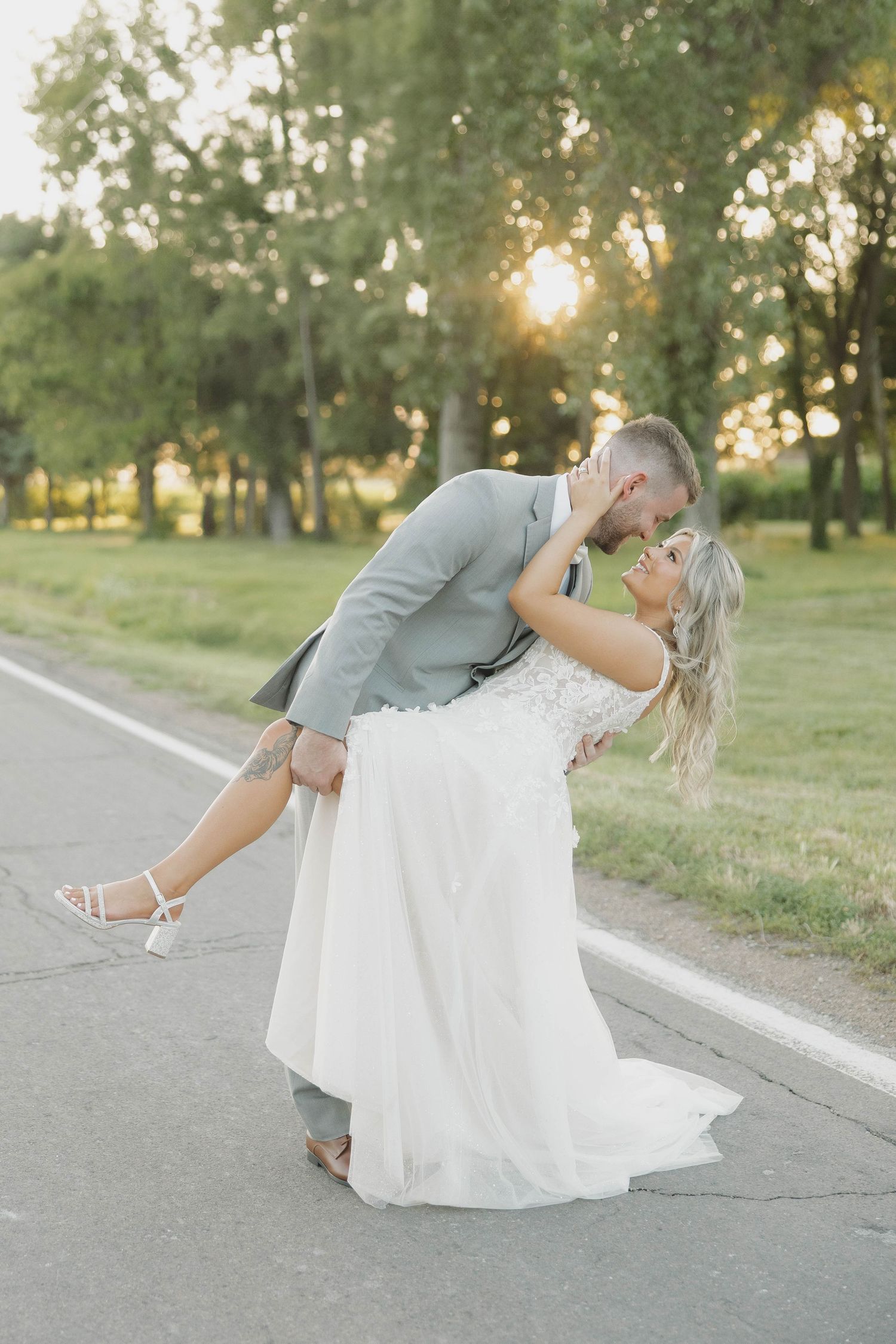 Series of romantic wedding photos showing a couple dancing and dipping on a paved road at sunset.