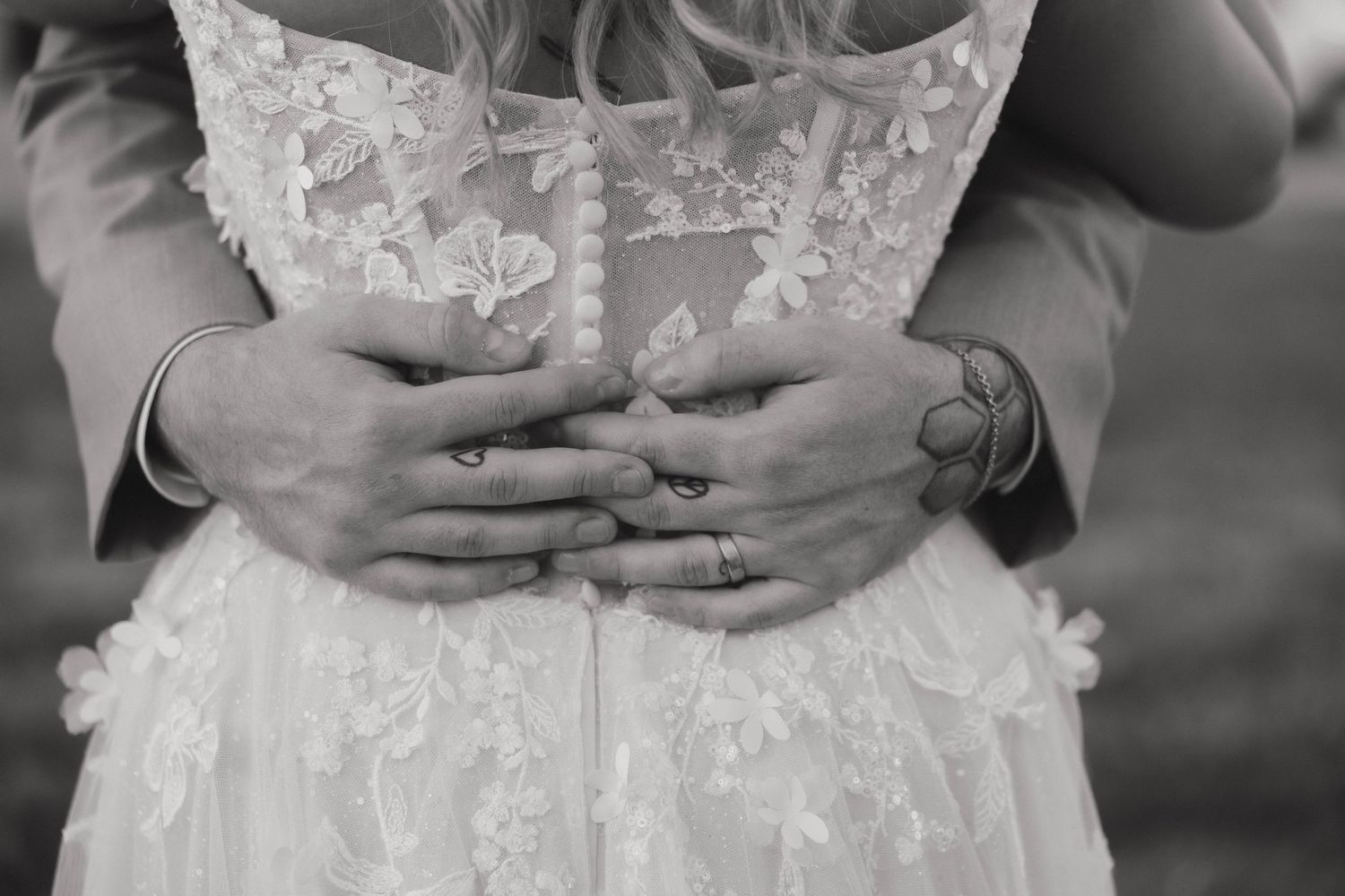 Close-up of white lace wedding dress details with delicate floral patterns and beading.