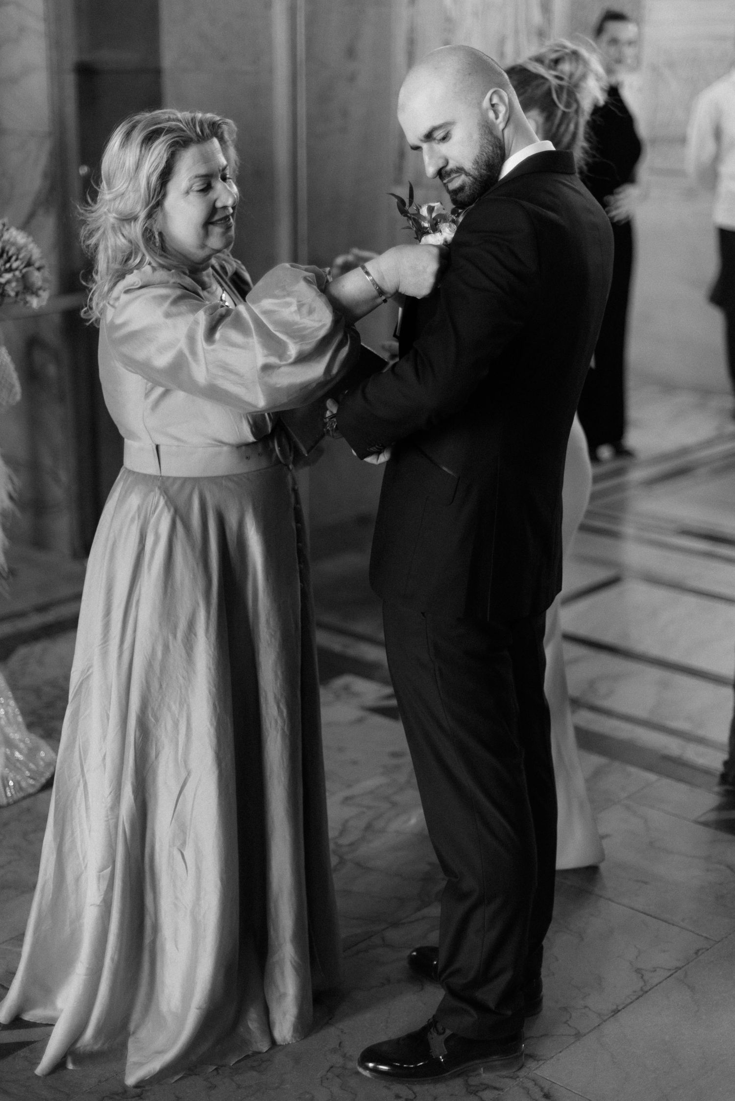 A series of black and white photos showing a couple dancing in formal attire at an elegant venue.