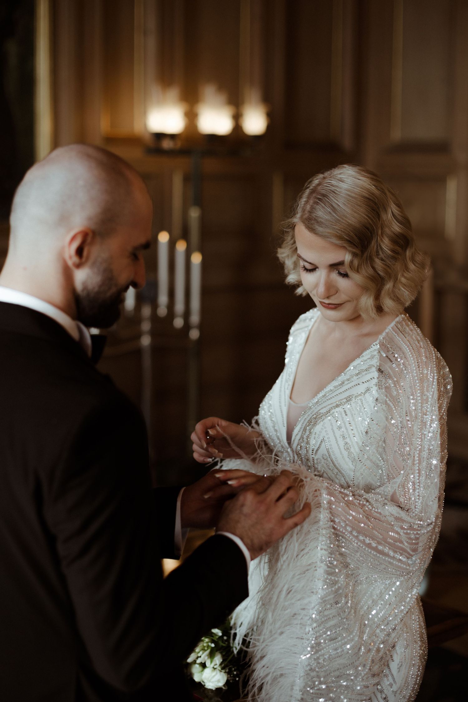 A couple exchanges rings during an intimate candlelit wedding ceremony with warm glowing ambiance.
