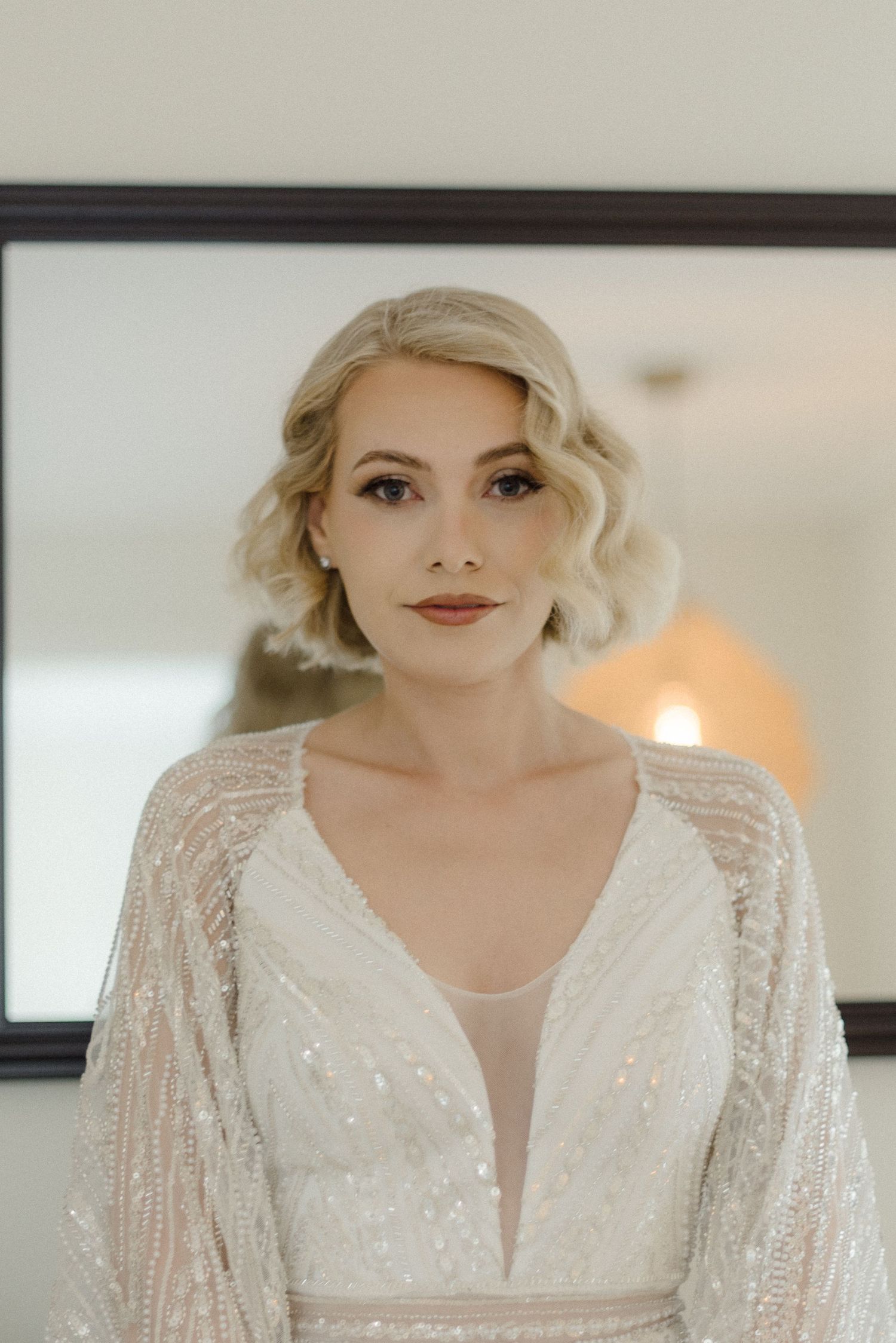 An elegant bridal portrait showcasing a vintage-inspired sequined gown and classic wavy hairstyle.